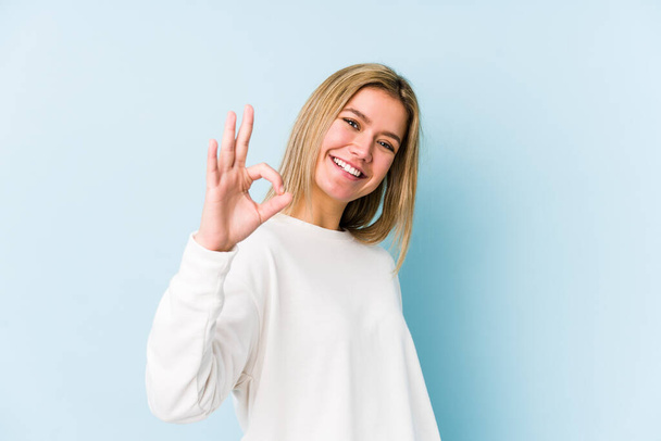Young blonde caucasian woman isolated cheerful and confident showing ok gesture. - Foto, imagen