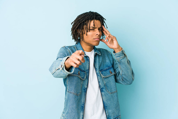 Young black man wearing a jeans jacket pointing temple with finger, thinking, focused on a task. - Photo, image