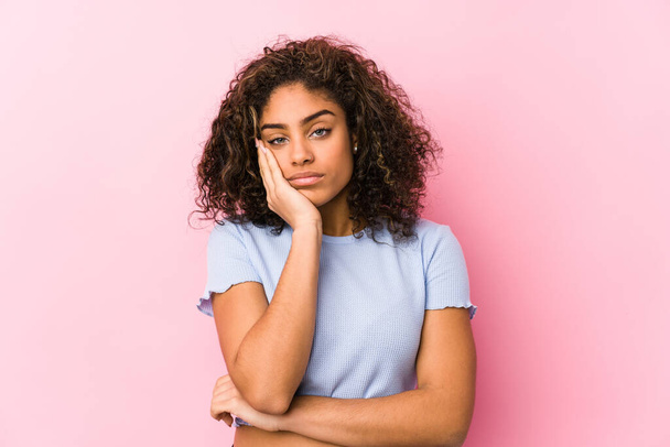 Young african american woman against a pink background who is bored, fatigued and need a relax day. - Fotoğraf, Görsel