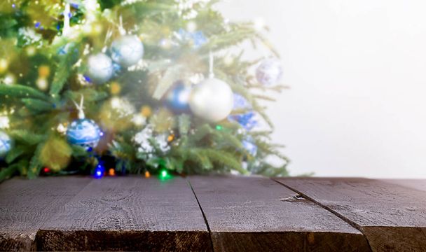 Χριστουγεννιάτικο δέντρο στο Ντεφόκους. σε πρώτο πλάνο ένα ξύλινο τραπέζι - Φωτογραφία, εικόνα