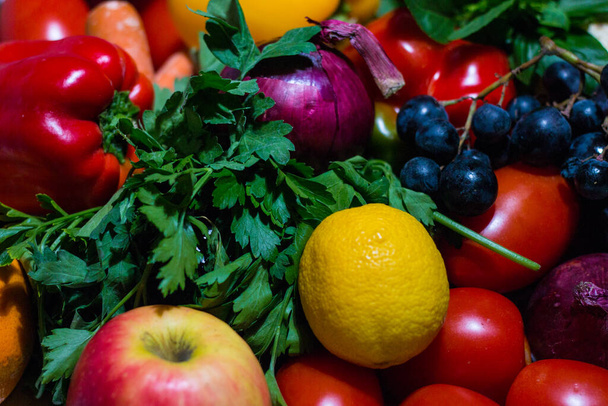 Sebzelerin arka planı farklı taze çiftlik sebzeleri. Yiyecek ya da Sağlıklı Diyet Konsepti, Üst Manzara ve Işık Efektleri. Çeşitli organik sebzelerle kompozisyon. Detoks diyeti: limon, domates, biber, karnabahar, elma, üzüm - Fotoğraf, Görsel