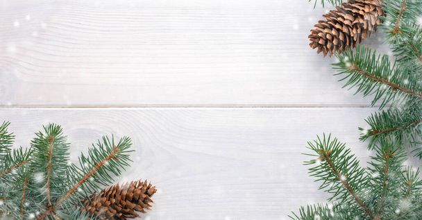 Abeto de Navidad con piñas y nieve en una tabla de madera blanca y espacio de copia para su texto. Banner.Flat lay - Foto, imagen