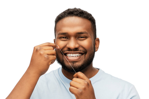 happy african man with dental floss cleaning teeth - Fotografie, Obrázek