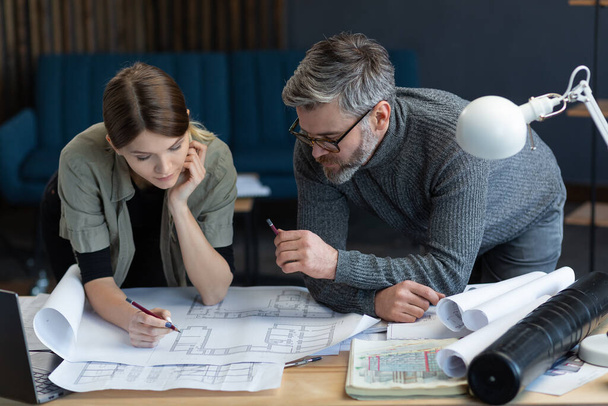 Engineer team working in office with blueprints and architect equipment, sketching, negotiating and planning construction project. Partners discussing at work. Business construction concept - Foto, imagen