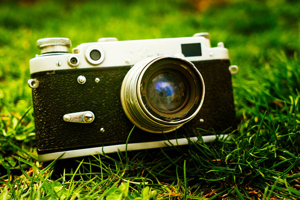 Vintage sowjetischen Film Fotokamera liegt auf dem Gras in der Natur Flache Schärfentiefe mit Fokus auf die Kamera. Draußen. Retro-Stil. - Foto, Bild