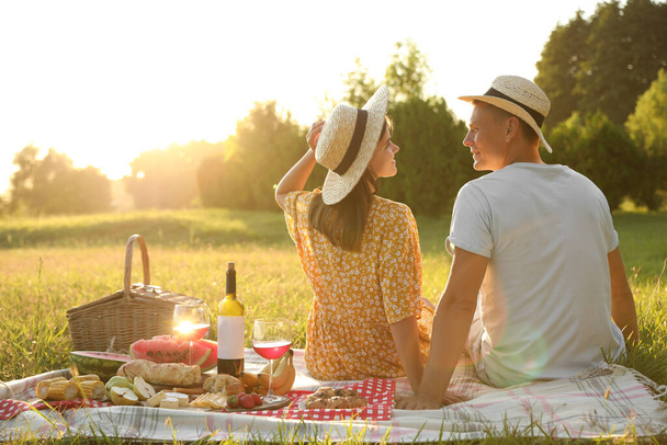 Happy couple having picnic in park on sunny day - Photo, image