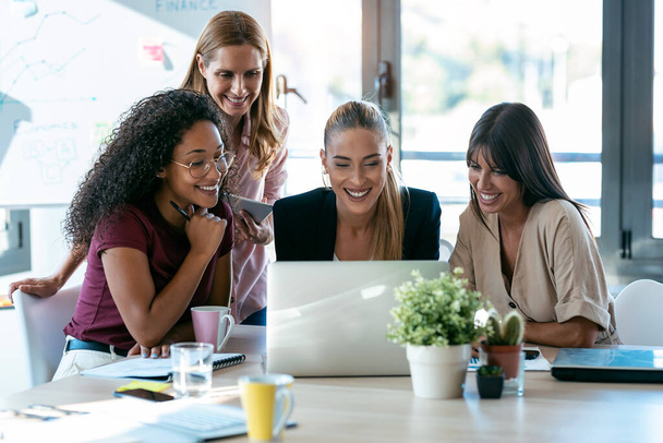 Snímek čtyř krásných chytrých obchodních žen pracovat s notebooky na stole v kooperačním prostoru v kanceláři.  - Fotografie, Obrázek