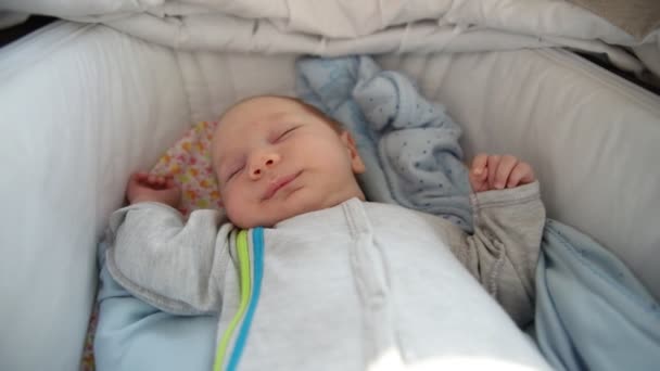 Un bebé recién nacido durmiendo tranquilamente en la cuna - Imágenes, Vídeo