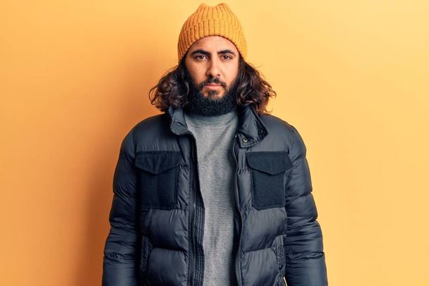 Hombre árabe joven que usa ropa casual de invierno con expresión seria en la cara. simple y natural mirando a la cámara.  - Foto, imagen