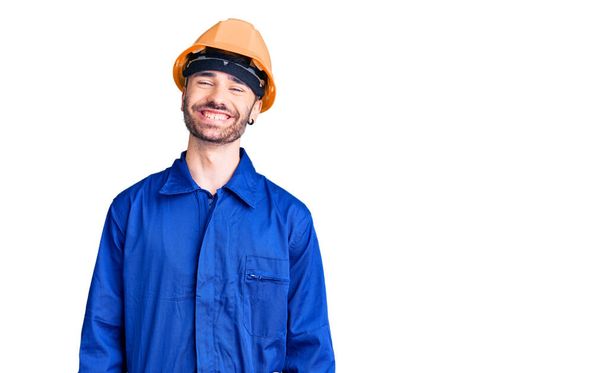 Joven hombre hispano vistiendo uniforme de trabajador con una sonrisa alegre y fresca en la cara. persona afortunada.  - Foto, Imagen