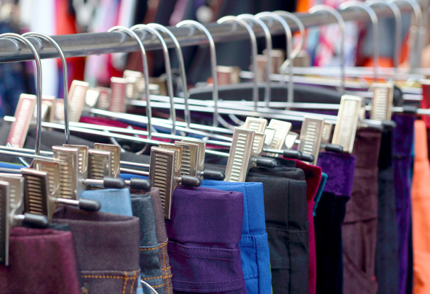 Shop pants hanging on a rack market. - Photo, Image