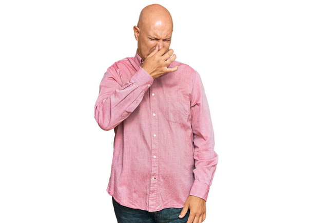 Keski-ikäinen kalju mies päällään rento vaatteet haisee jotain haiseva ja inhottava, sietämätön haju, pidätys hengitys sormet nenässä. paha haju  - Valokuva, kuva