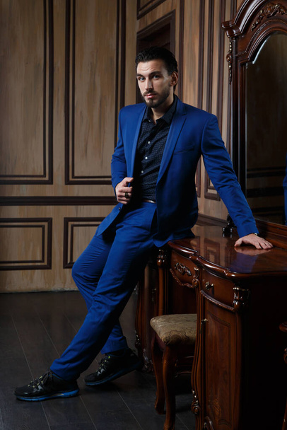 Attractive man in an elegant blue suit in a classic interior. - Foto, afbeelding