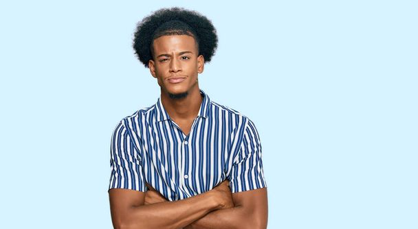 Afrikkalainen amerikkalainen mies afro hiukset yllään rento vaatteita skeptinen ja hermostunut, paheksuva ilme kasvot ristissä kädet. negatiivinen henkilö.  - Valokuva, kuva