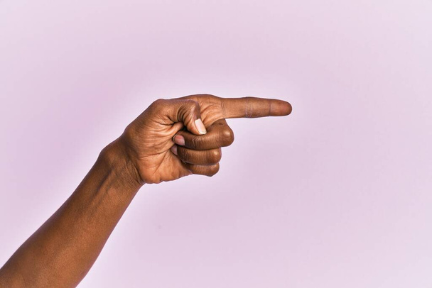 Χέρι και το χέρι της μαύρης γυναίκας μέσης ηλικίας πάνω από ροζ απομονωμένο φόντο δείχνοντας με δείκτη στο πλάι, προτείνοντας και επιλέγοντας μια επιλογή  - Φωτογραφία, εικόνα