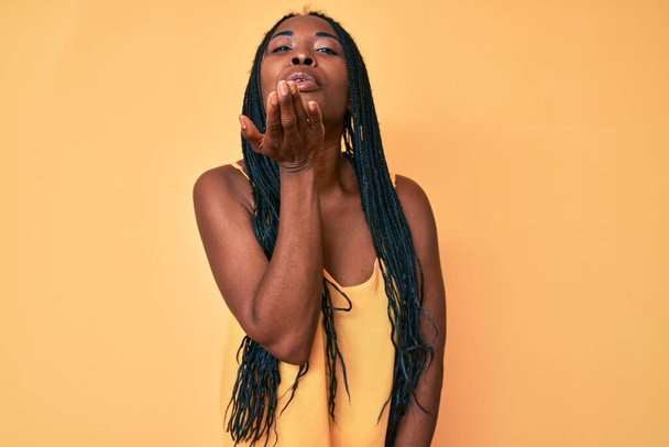 African american woman with braids wearing casual clothes looking at the camera blowing a kiss with hand on air being lovely and sexy. love expression.  - Foto, imagen