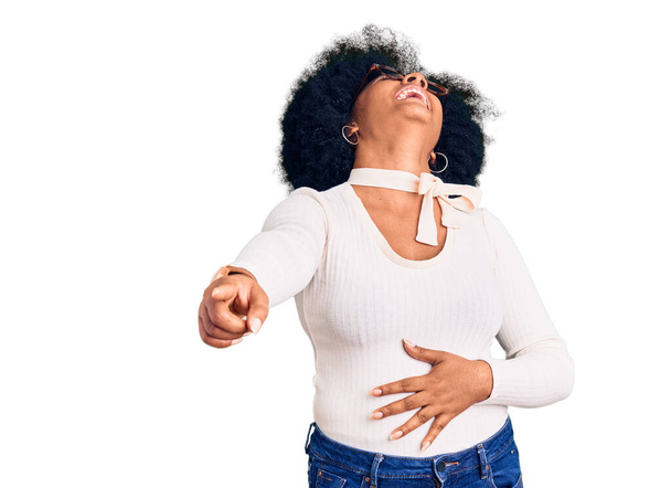 Young african american girl wearing casual clothes and glasses laughing at you, pointing finger to the camera with hand over body, shame expression  - Фото, изображение