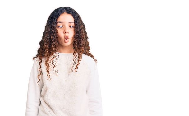 Beautiful kid girl with curly hair wearing casual clothes making fish face with lips, crazy and comical gesture. funny expression.  - Foto, Imagen