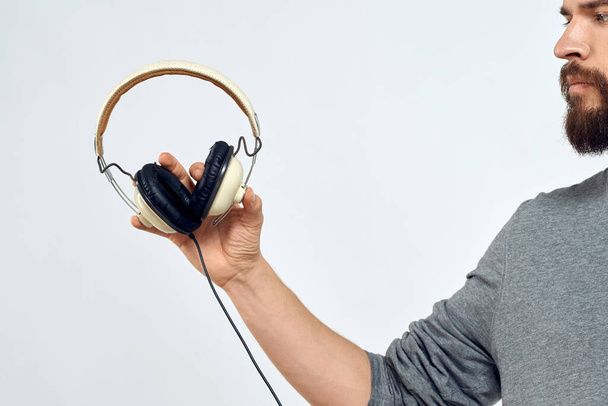 Hombre sosteniendo los auriculares en las manos de un hombre estilo de vida moderna tecnología recortada vista - Foto, imagen