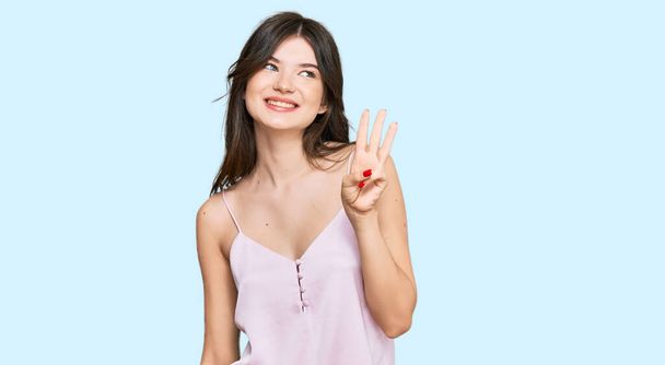 Mladý krásný kavkazský dívka na sobě ležérní oblečení ukazuje a ukazuje s prsty číslo tři a zároveň se usmívá sebevědomě a šťastně.  - Fotografie, Obrázek