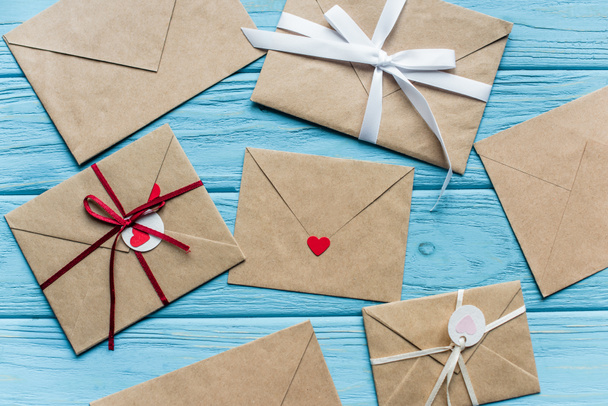 vista superior de fundo azul de madeira com envelopes e corações - Foto, Imagem