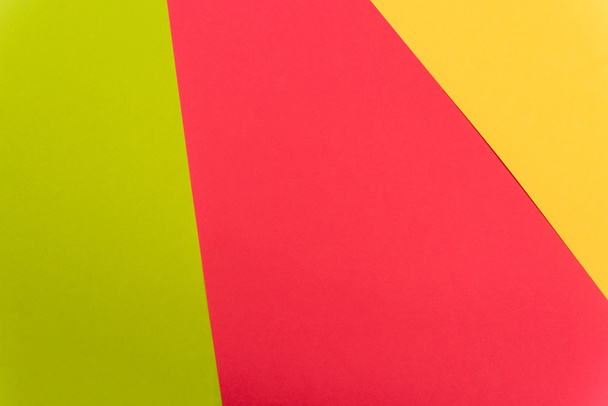 top view of colorful abstract yellow, red, green paper background - Foto, imagen