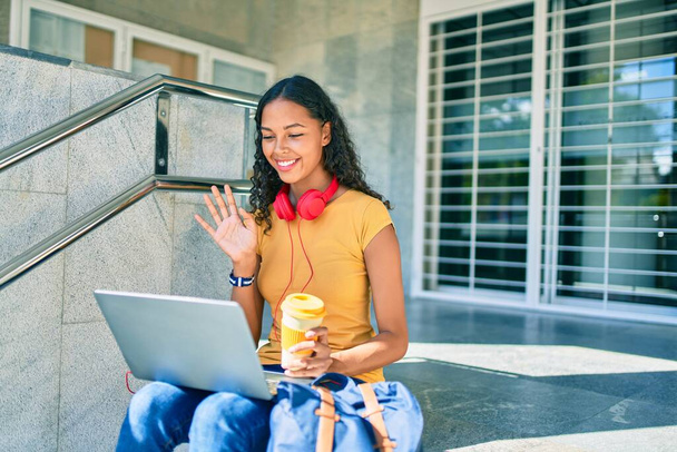 Młoda afrykańska studentka wykonuje rozmowy wideo za pomocą laptopa na uniwersytecie. - Zdjęcie, obraz