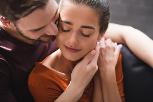 tender man touching face of beloved woman sitting with closed eyes - Photo, Image