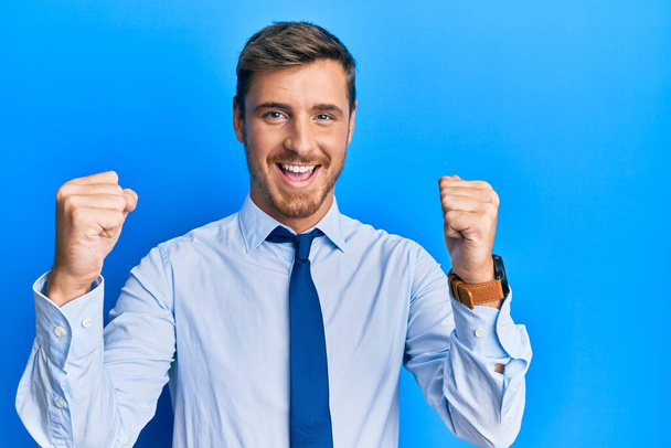 Красивый белый мужчина в деловой рубашке и галстуке гордо кричит, празднует победу и успех очень взволнован с поднятыми руками  - Фото, изображение