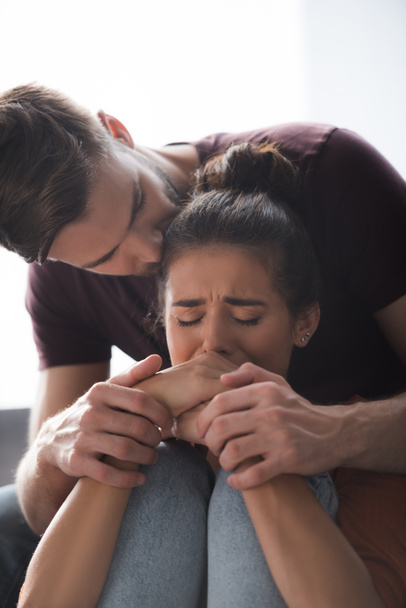 tender man touching hands of depressed girlfriend crying with closed eyes - Photo, image