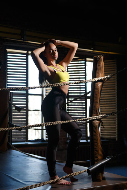 Slender girl athlete stands in the ring in the gym. - Photo, image