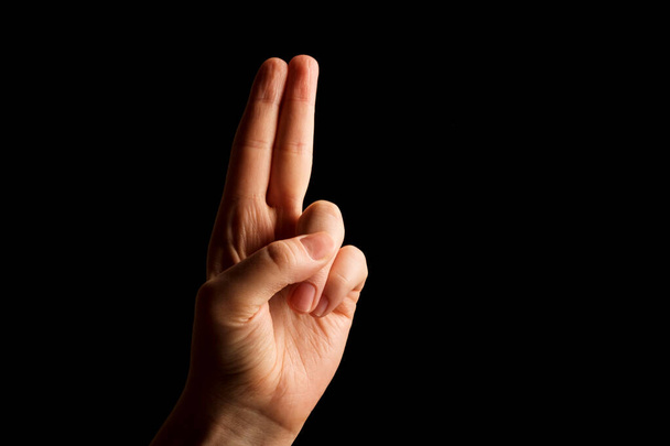 Main montrant le signe de l'alphabet U en langue des signes américaine (ASL), isolé sur fond noir. Langue des signes - Photo, image