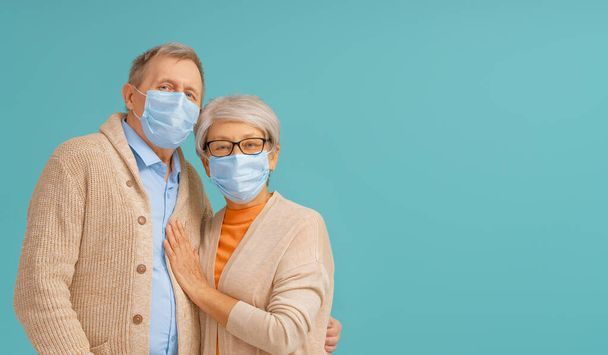 Senior couple wearing facemask during coronavirus and flu outbreak. Virus and illness protection, home quarantine. COVID-2019. Taking on masks. - Foto, afbeelding