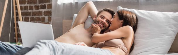 чуттєва жінка торкається обличчя сексуального хлопця, лежачи в ліжку разом, банер
 - Фото, зображення