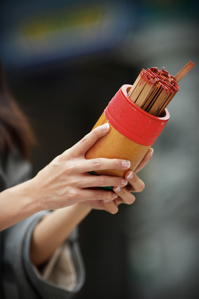 Soothsaying, sacudir el cilindro de bambú para la fortuna decir
 - Foto, Imagen
