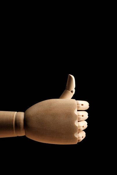 Дерев'яна рука манекена для малювання вказує напрямок індексного пальця на чорному тлі. Точковий палець. Вид збоку. Художня модель для малювання. Частина тіла - рука, пензель
. - Фото, зображення