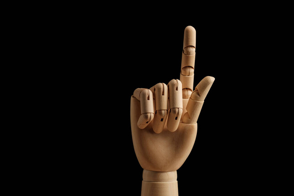 Дерев'яна рука манекена для малювання вказує напрямок індексного пальця на чорному тлі. Вчимося рахувати - один. Художня модель для малювання. Частина тіла - рука, пензель. Протягніть
 - Фото, зображення