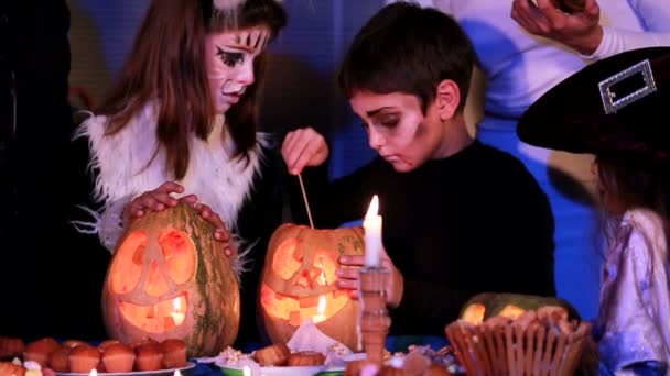 Children in suits extinguish candles in pumpkins. Slow motion. - Footage, Video