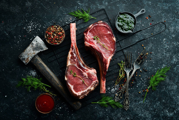 Raw beef steak on the grill. Steak on the bone. Top view. Free copy space. - Zdjęcie, obraz