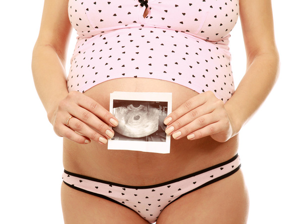 A pregnant woman holding an ultrasound - Foto, afbeelding