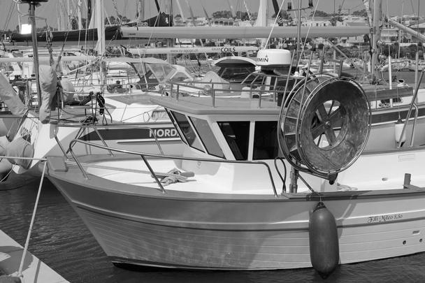 Італія, Сицилія, Марина-ді-Рагуса (провінція Рагуса), 18 вересня 2020 року, сицилійський рибальський човен і розкішні яхти в порту - ЕДИТОРІАЛ - Фото, зображення