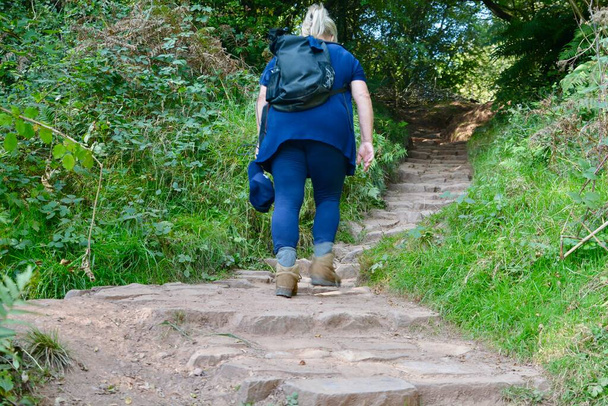 Reife Frau, die allein in der walisischen Landschaft spazieren geht, lebhaft, sicher, sozial distanziert, gesunde Freizeitaktivität an der frischen Luft. Das neue normale Berg- / Hügelwandern in Abergavenny Wales - Foto, Bild