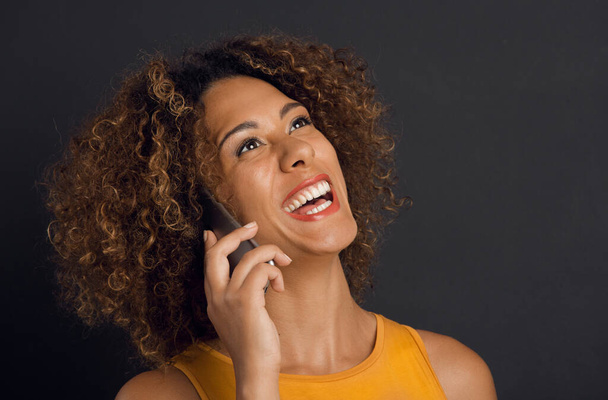 Beautiful African American woman making a phone call and laughing - 写真・画像