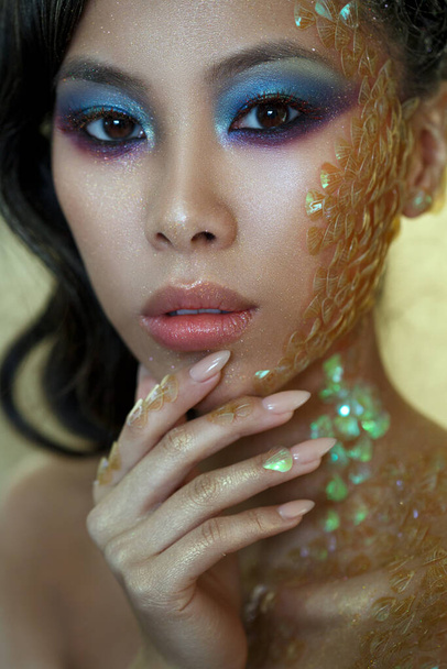 Beauty portrait of a beautiful Asian girl with creative makeup of a mermaid and facial scales. - Foto, Imagem