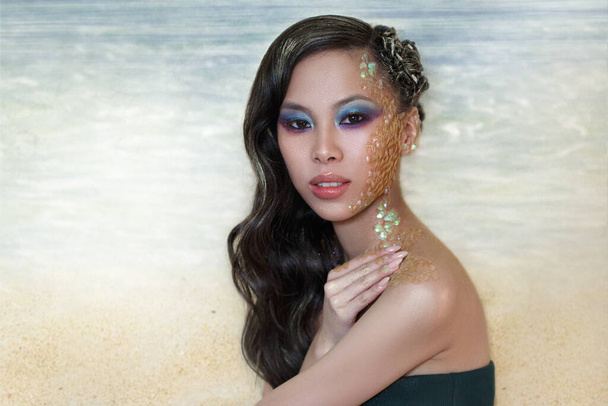 Beauty portrait of a beautiful Asian girl with creative makeup of a mermaid and facial scales. - Foto, immagini