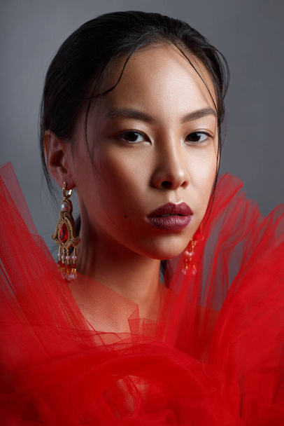 Beauty portrait of a beautiful asian girl in red Isolated on gray background. - 写真・画像