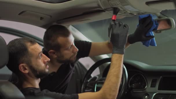 lähikuva ammunta autopesulatyöntekijät, kaksi työntekijää auton sisätilojen puhdistus osat liasta, voihkiminen työntekijöiden kasvot - Materiaali, video