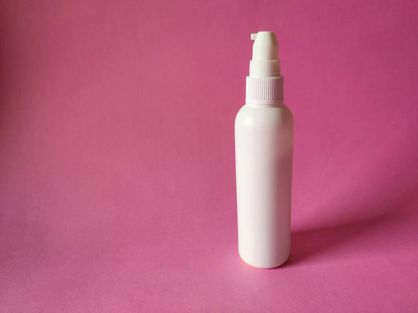 Butelka z białym aerozolem do produktu kosmetycznego. Izolacja na różowym tle.Mock do brandingu, reklamy - Zdjęcie, obraz