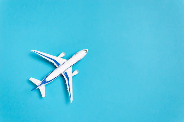 Λευκό αεροπλάνο σε μπλε φόντο με αντίγραφο χώρου για κείμενο. Ελάχιστη ταξιδιωτική έννοια - Φωτογραφία, εικόνα