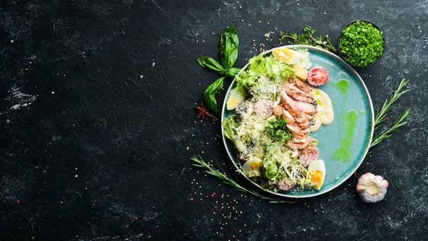 Caesar salad with chicken. Vegetable salad with chicken fillet. Top view. Rustic style. - 写真・画像